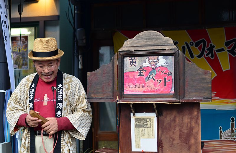 Figure 10: A contemporary kamishibai performer in Tokyo. Note the stage-like wooden box, into which paper panels are inserted. Photo by Aki Sato.
